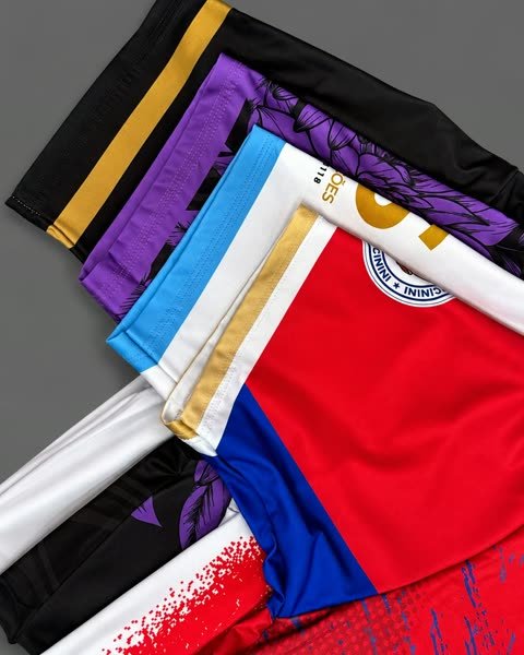 Punhos de cinco uniformes abertos em leque, mostrando as faixas de contraste